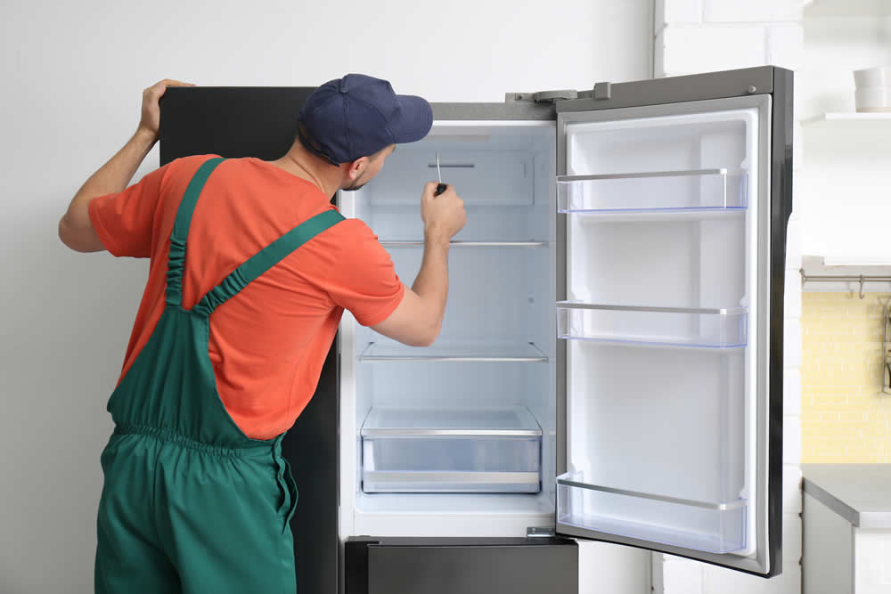 Handwerker repariert Kühlschrank